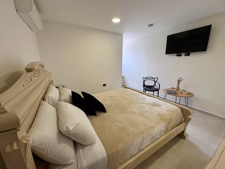 Dormitorio moderno con televisión y aire acondicionado en Medellín
