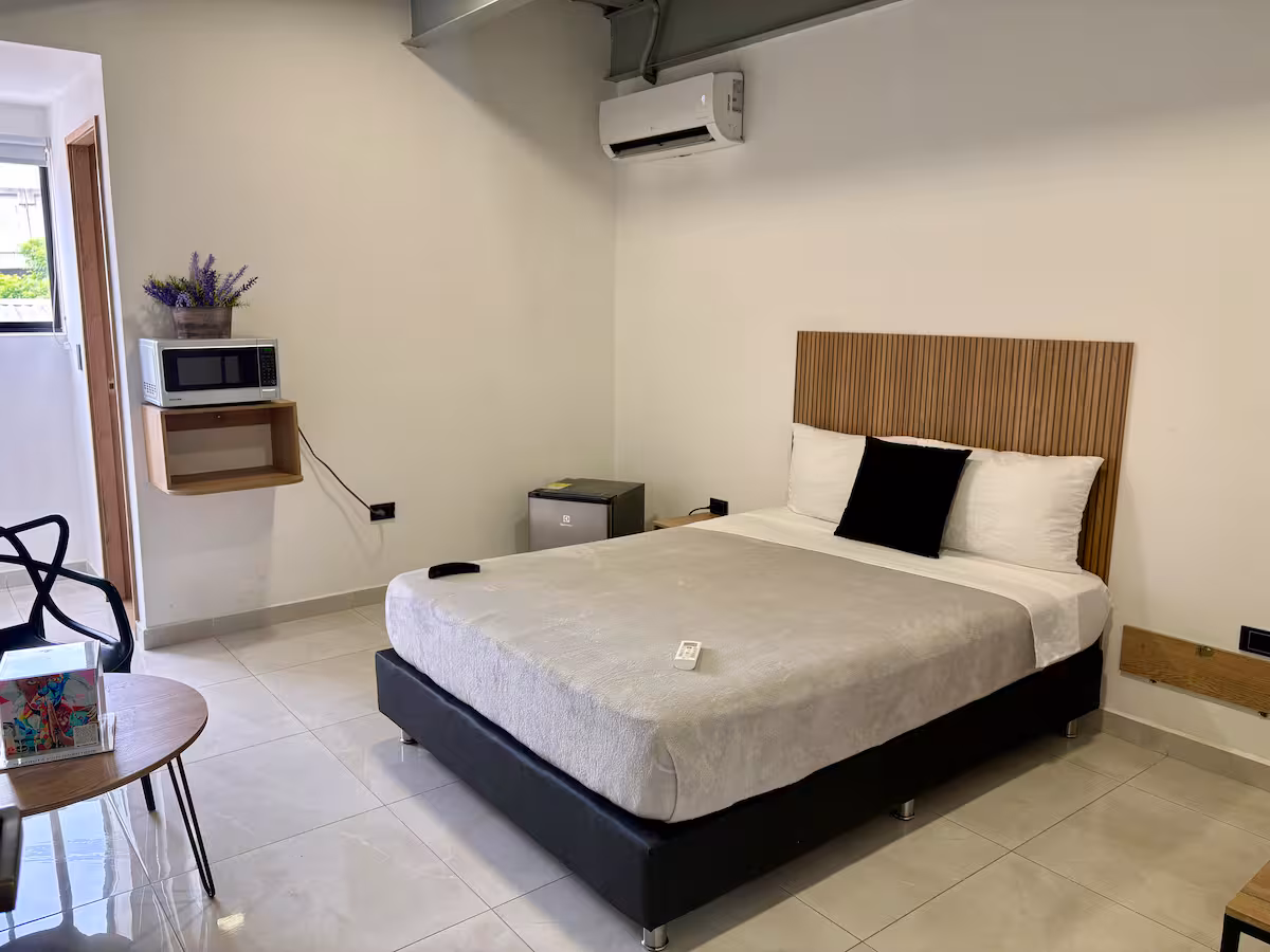 Estudio amoblado en Medellín con cama doble, escritorio y ventana con luz natural