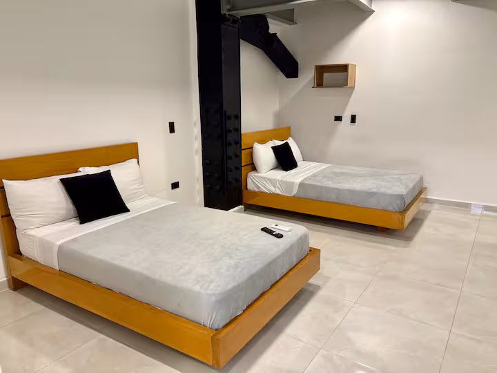 Dormitorio con cama doble y estructura industrial en estudio amoblado de Medellín