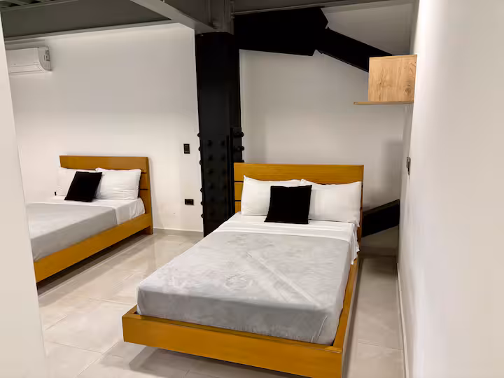 Habitación privada con cama doble y detalles de diseño industrial moderno
