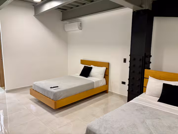 Vista amplia de estudio amoblado con cama doble y aire acondicionado en Medellín