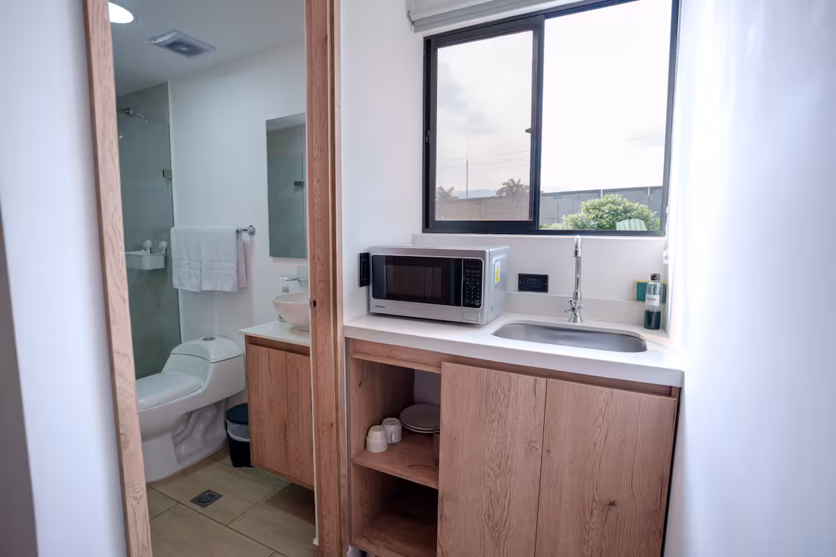 Cocineta equipada con microondas, lavaplatos y ventana con vista exterior en Medellín