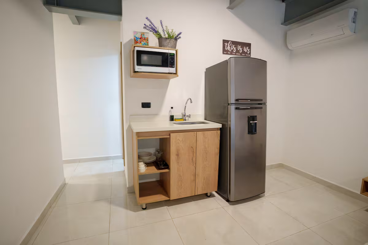 Cocineta equipada con microondas, cafetera y minibar en estudio amoblado