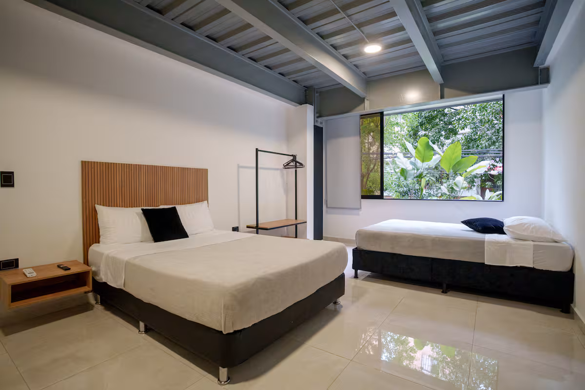 Vista interior de estudio amoblado con cama doble y cocineta integrada