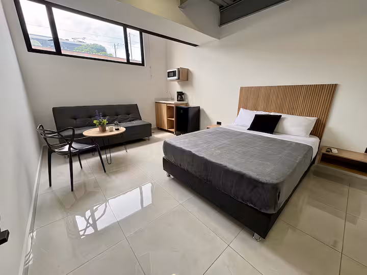 Dormitorio moderno con televisión en apartamento amoblado de Medellín