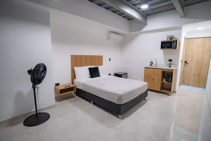 Habitación amplia con cama doble y ventilador en apartamento amoblado de Medellín