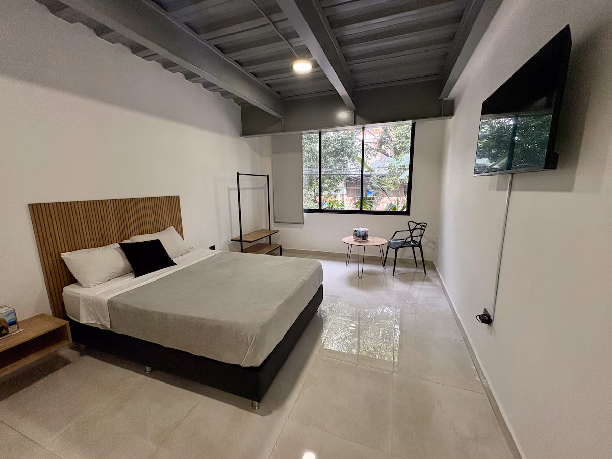 Habitación moderna con cama doble y diseño industrial en Medellín